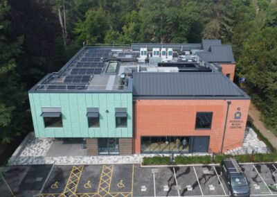aerial view of new college building with trees behind and parking bays in front