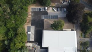 aerial view of new college building surrounded by trees