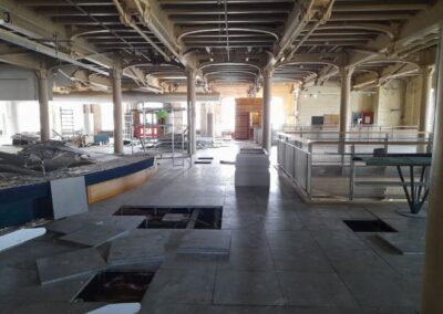 room with pillars across the middle being cleared ready for refurbishment