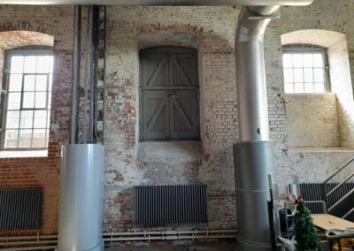 exposed pipework with raised windows and doorway with radiators below
