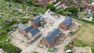 aerial view of new houses being built with allotments in the background