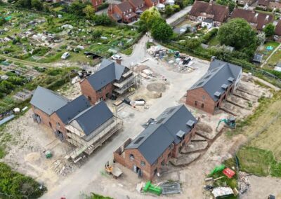 aerial view of new houses being built with allotments in the background