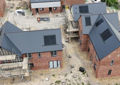 aerial view of new house building site with scaffolding on buildings